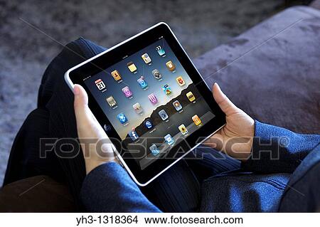 Picture - A business woman showing her iPad applications screen in an office. Fotosearch