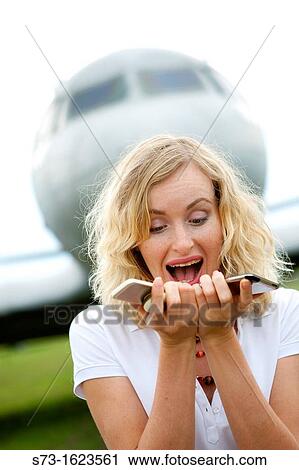 A business woman with two mobiles phones next to plane View Large Photo Image Stock Image - A business woman with two mobiles phones next to plane. Fotosearch