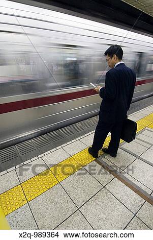 A businessman waits on a subway platform Tokyo Japan View Large Photo Image Picture - A businessman waits on a subway platform Tokyo Japan. Fotosearch