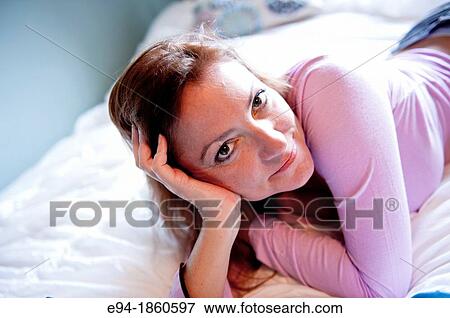 A casual portrait of a 38 year old redheaded woman lying on a bed View Large Photo Image Stock Photo - A casual portrait of a 38 year old redheaded woman lying on a bed. Fotosearch