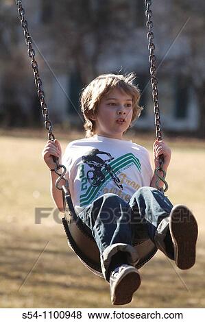 A caucasian boy, 5-10, on a swing at the park View Large Photo Image Stock Photo - A caucasian boy, 5-10, on a swing at the park. Fotosearch