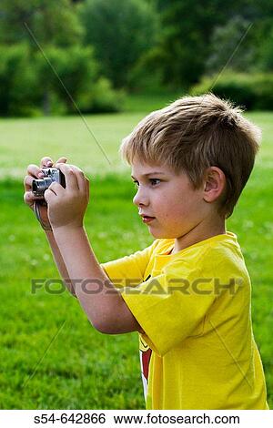 A caucasian boy, 5-10, taking a photograph at a park. View Large Photo Image Stock Photograph - A caucasian boy, 5-10, taking a photograph at a park.. Fotosearch