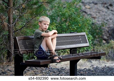 A caucasian boy, 5 to 10, seated on a bench looking unhappy View Large Photo Image Stock Image - A caucasian boy, 5 to 10, seated on a bench looking unhappy. Fotosearch