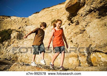 A caucasian boy and mixed race mexican & caucasian girl try to keep their balance on a rocky ledge at a beach in Santa Cruz, California Northern California coastal beaches are well known for their rocky terrains and cliffsides View Large Photo Image Stock Photo - A caucasian boy and mixed race mexican & caucasian girl try to keep their balance on a rocky ledge at a beach in Santa Cruz, California Northern California coastal beaches are well known for their rocky terrains and cliffsides. Fotosearch