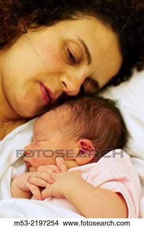 Picture - A caucasian mother with her newborn baby girl.. Fotosearch
