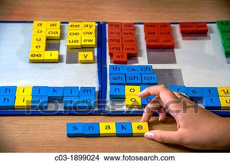 A certified dyslexia testing specialist in a uses colored tile manipulation for a multisensory approach to spelling words for a dyslexic pupil View Large Photo Image Picture - A certified dyslexia testing specialist in a uses colored tile manipulation for a multisensory approach to spelling words for a dyslexic pupil. Fotosearch