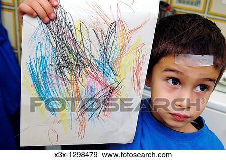 Stock Photo - A child holding up his drawing. Fotosearch