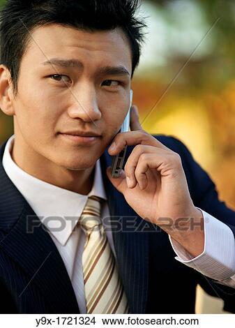 A Chinese business on his mobile phone View Large Photo Image Picture - A Chinese business on his mobile phone. Fotosearch