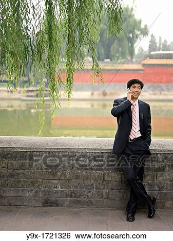 A Chinese business on his mobile phone View Large Photo Image Stock Photograph - A Chinese business on his mobile phone. Fotosearch
