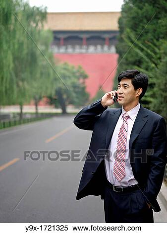 A Chinese business on his mobile phone View Large Photo Image Stock Photography - A Chinese business on his mobile phone. Fotosearch