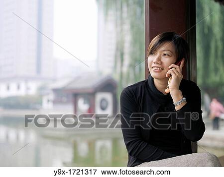 A Chinese business woman in a suit checking her email on her laptop through wireless internet with a lake and traditional Chinese architecture in the background View Large Photo Image Stock Photo - A Chinese business woman in a suit checking her email on her laptop through wireless internet with a lake and traditional Chinese architecture in the background. Fotosearch