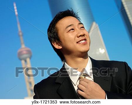 A chinese man in suit smiles and fixes his tie as he stands before the pearl tower n Shanghai View Large Photo Image Stock Image - A chinese man in suit smiles and fixes his tie as he stands before the pearl tower n Shanghai. Fotosearch