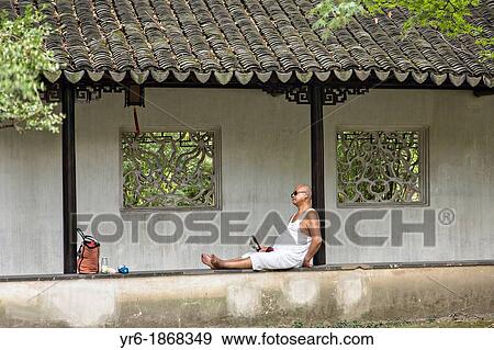 Stock Photo - A Chinese man rests in the Humble Administrator's garden in Suzhou, China. Fotosearch