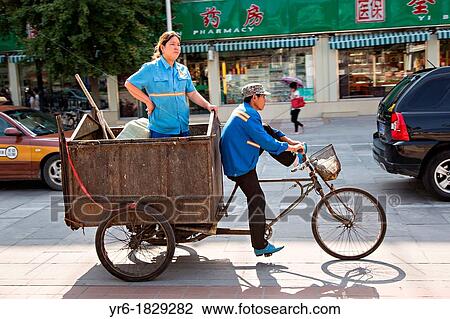 A Chinese woman rides in the back of a trash tricycle during summer in Beijing, China View Large Photo Image Stock Image - A Chinese woman rides in the back of a trash tricycle during summer in Beijing, China. Fotosearch