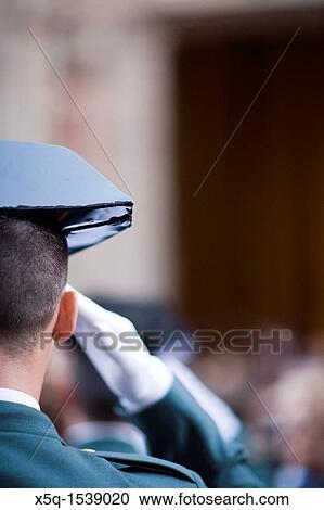 Stock Image - A Civil Guard saluting while a Holy Week procession, Seville, Spain. Fotosearch