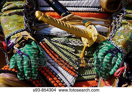 Picture - A close-up of the front of a Japanese dressed up as a samurai for the Jidai Matsuri Festival of Ages in Kyoto, showing swords and colorful body armor. Fotosearch