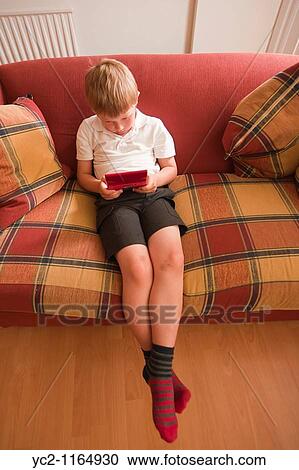 Stock Image - A close up picture of a six year old boy playing on a nintendo DS handheld computer game console in the Uk. Fotosearch