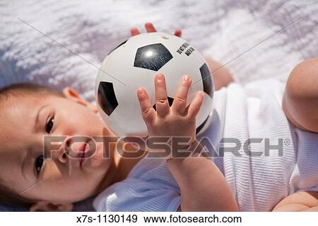 A close up view of a baby boy playing with a soccer ball outside View Large Photo Image Stock Photo - A close up view of a baby boy playing with a soccer ball outside. Fotosearch
