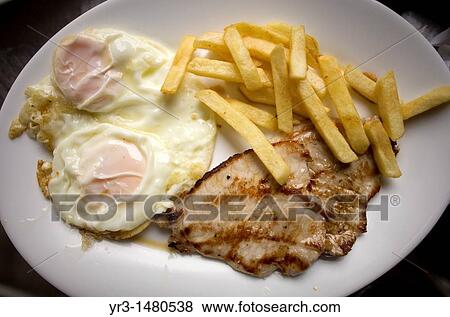 Stock Photo - A combination plate or plato combinado with fried eggs, fried potatoes and tenderloin sit in a restaurant of Cordoba, Andalusia, Spain, april 18, 2011. Fotosearch