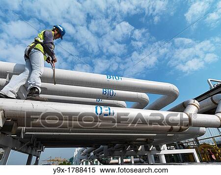 A construction worker measures pipes in Johor, Malaysia View Large Photo Image Stock Photography - A construction worker measures pipes in Johor, Malaysia. Fotosearch