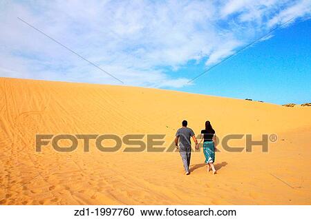 A couple climbs to the top of the Great Sand Dune near Ashdod, Israel. View Large Photo Image Stock Image - A couple climbs to the top of the Great Sand Dune near Ashdod, Israel.. Fotosearch