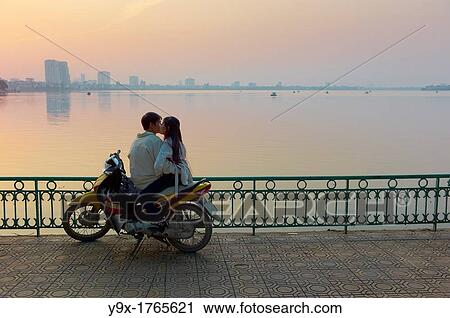 A couple on a motorbike by West Lake during sunset View Large Photo Image Stock Image - A couple on a motorbike by West Lake during sunset. Fotosearch