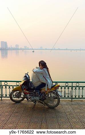 A couple on a motorbike by West Lake during sunset View Large Photo Image Stock Image - A couple on a motorbike by West Lake during sunset. Fotosearch