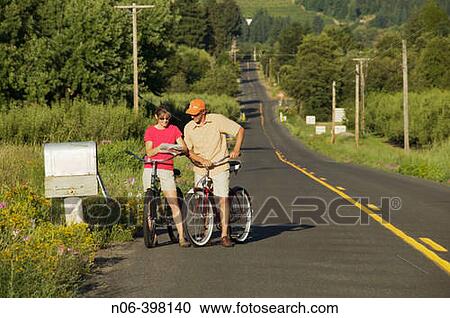A couple read their mail by a country mailbox while riding their bike in Parkdale, Oregon. USA. View Large Photo Image Stock Image - A couple read their mail by a country mailbox while riding their bike in Parkdale, Oregon. USA.. Fotosearch