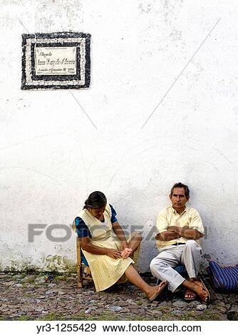 A couple rest as they wait for customers at a souvenirs small market in Taxco de Alarcon, Guerrero State, Mexico. View Large Photo Image Stock Photo - A couple rest as they wait for customers at a souvenirs small market in Taxco de Alarcon, Guerrero State, Mexico.. Fotosearch