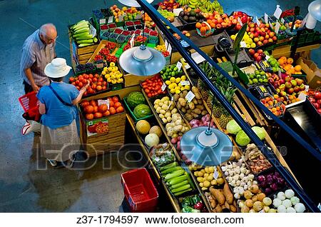 Stock Photo - A couple shopping at an indoor market for fresh fruit and vegetables, Ontario, Canada. Fotosearch