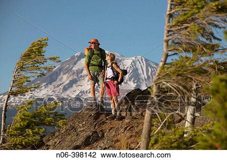 Stock Image - A couple take a break while hiking near Mount Adams. Washington. USA. Fotosearch