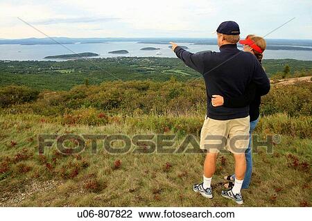 Stock Image - a couple viewing bar harbor from cadillac mountain acadia NP in maine usa. Fotosearch