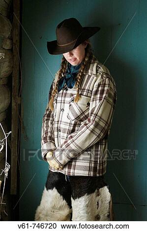 A cowgirl deep in thought, leaning against the cabin wall View Large Photo Image Stock Image - A cowgirl deep in thought, leaning against the cabin wall. Fotosearch