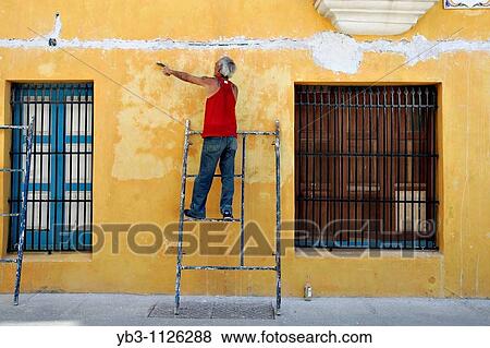 A Cuban worker prepares the outside of a building for repainting, Havana, Cuba View Large Photo Image Stock Photo - A Cuban worker prepares the outside of a building for repainting, Havana, Cuba. Fotosearch