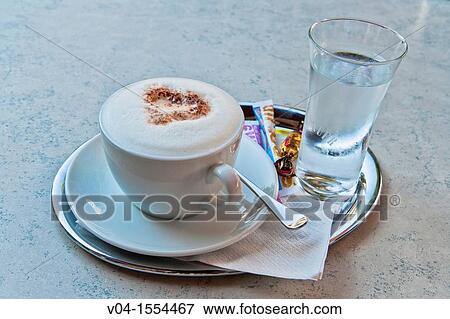 A cup of cappuccino and a glass of water View Large Photo Image Stock Photo - A cup of cappuccino and a glass of water. Fotosearch