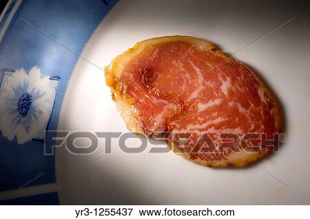 A cured loin slice made from Spanish Iberian pigs, the source of Iberico ham known as pata negra, sits on a plate in Prado del Rey, Sierra de Cadiz, Cadiz province, Andalusia, Spain. View Large Photo Image Stock Photo - A cured loin slice made from Spanish Iberian pigs, the source of Iberico ham known as pata negra, sits on a plate in Prado del Rey, Sierra de Cadiz, Cadiz province, Andalusia, Spain.. Fotosearch