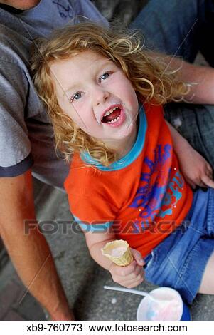 Stock Image - A cute girl eating ice cream. Fotosearch