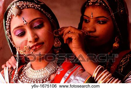 A dancer is helping another to hang on an earring. From Rajasthan, India. View Large Photo Image Stock Photograph - A dancer is helping another to hang on an earring. From Rajasthan, India.. Fotosearch