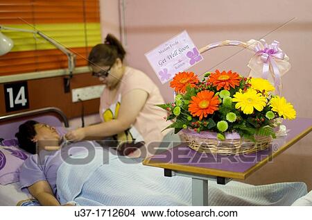 A daughter feeding a sick mother with get well soon card View Large Photo Image Picture - A daughter feeding a sick mother with get well soon card. Fotosearch