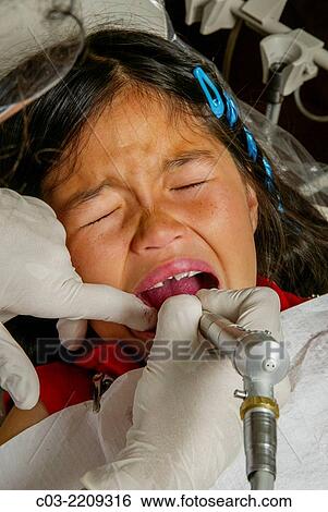 A dentist cleans an Asian American girl patient's teeth in Newport Beach, CA. Note latex gloves. MODEL RELEASE. View Large Photo Image Stock Photograph - A dentist cleans an Asian American girl patient's teeth in Newport Beach, CA. Note latex gloves. MODEL RELEASE.. Fotosearch