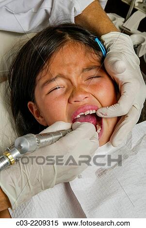 A dentist cleans an Asian American girl patient's teeth in Newport Beach, CA. Note latex gloves. MODEL RELEASE. View Large Photo Image Stock Photography - A dentist cleans an Asian American girl patient's teeth in Newport Beach, CA. Note latex gloves. MODEL RELEASE.. Fotosearch