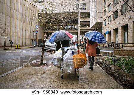 A deposit bottle collector passes a pedestrian in the Chelsea neighborhood of New York View Large Photo Image Stock Image - A deposit bottle collector passes a pedestrian in the Chelsea neighborhood of New York. Fotosearch