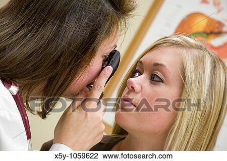 A doctor examining a teenage female patient with an eye scope View Large Photo Image Stock Image - A doctor examining a teenage female patient with an eye scope. Fotosearch