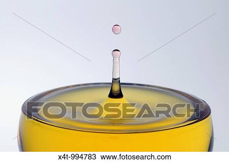 A drop of pink water falling into a glass of yellow liquid forming a column with a drop on top View Large Photo Image Stock Image - A drop of pink water falling into a glass of yellow liquid forming a column with a drop on top. Fotosearch