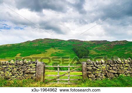 A dry stone wall and gate in the Lake District with Gowbarrow Fell in the distance, Cumbria, England. View Large Photo Image Stock Image - A dry stone wall and gate in the Lake District with Gowbarrow Fell in the distance, Cumbria, England.. Fotosearch