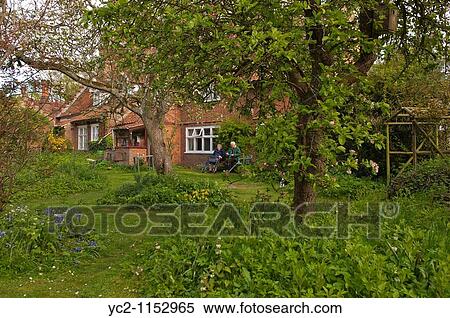 A elderly couple relax in their cottage garden in Suffolk, England, Great Britain, Uk View Large Photo Image Stock Photography - A elderly couple relax in their cottage garden in Suffolk, England, Great Britain, Uk. Fotosearch