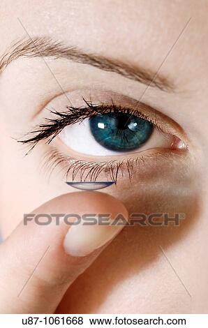 A facial close up of a young woman putting a contact lens onto his eye View Large Photo Image Stock Photo - A facial close up of a young woman putting a contact lens onto his eye. Fotosearch