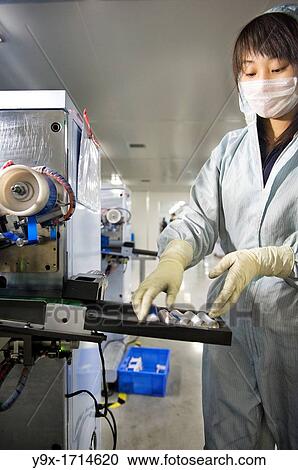 A factory worker dressed in an anti-contamination suit collecting battery cells as they come out of a machine. Shot in a Li-ion Battery Co which develops, manufactures, and markets cylindrical type rechargeable Li-ion batteries View Large Photo Image Stock Image - A factory worker dressed in an anti-contamination suit collecting battery cells as they come out of a machine. Shot in a Li-ion Battery Co which develops, manufactures, and markets cylindrical type rechargeable Li-ion batteries. Fotosearch