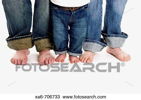 A family of three, mother, father and toddler son, stand on a white background wearing jeans. Only their legs and bare feet are shown. View Large Photo Image Stock Image - A family of three, mother, father and toddler son, stand on a white background wearing jeans. Only their legs and bare feet are shown.. Fotosearch