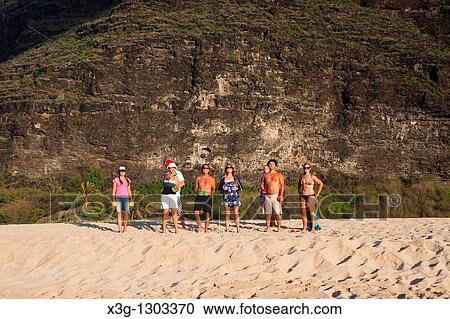 Stock Image - A family plays bocce ball alone an empty stretch of Polihale State Park beach, Kauai, Hawaii, USA. Fotosearch
